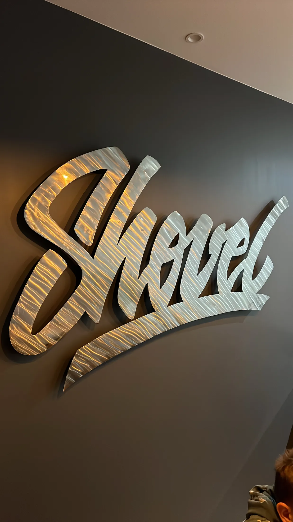Le logo Shovel en relief sur le mur noir